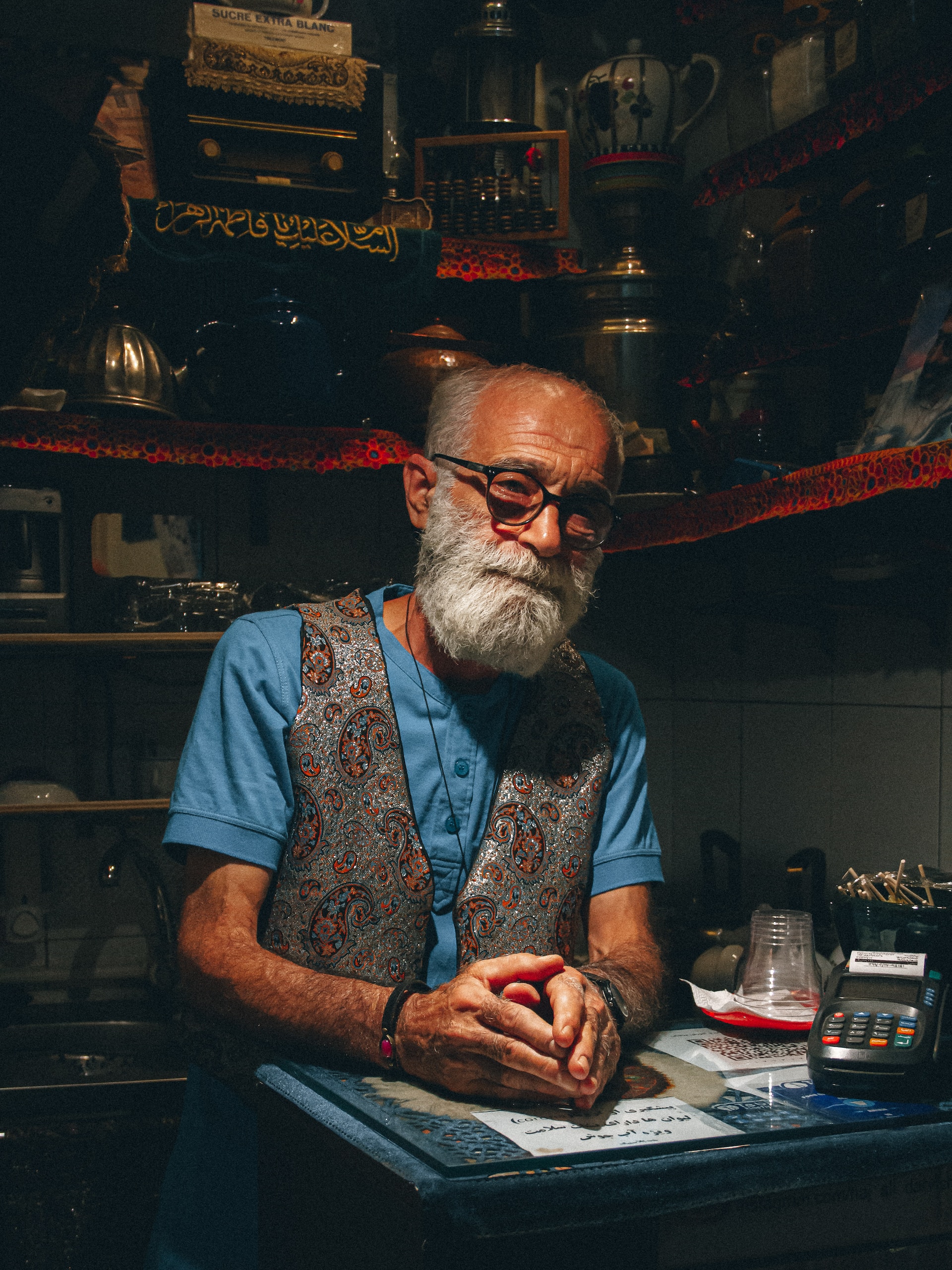 man in a blue and white floral button-up shirt wearing eyeglasses